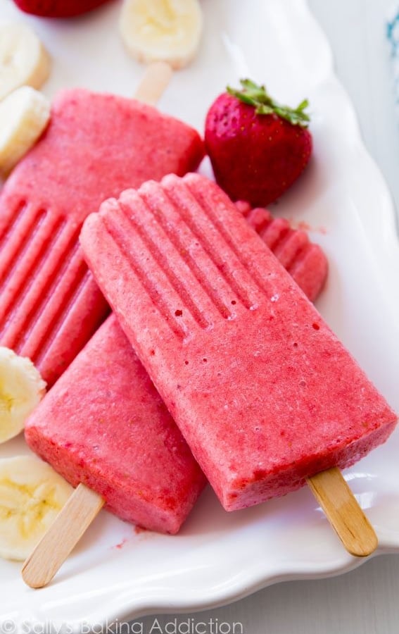 strawberry banana popsicles on a white serving tray